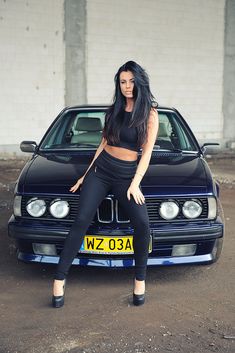 a woman sitting on the hood of a car