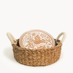 a woven basket with two decorative plates in it