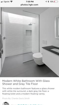 a white bathroom with glass shower and gray tile floor is featured in the new york times