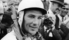 black and white photograph of man wearing helmet with other men in background looking at camera