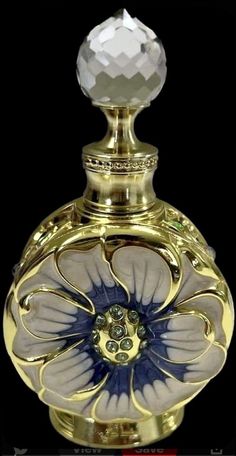 an ornate gold and blue glass bottle with a crystal ball on it's top