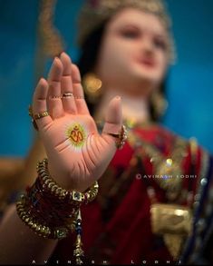 a close up of a person wearing jewelry and holding their hand in front of her face