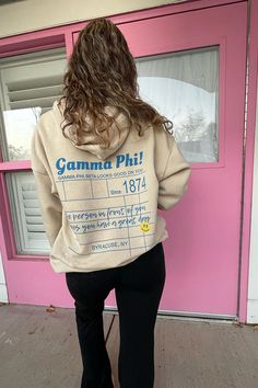 a woman standing in front of a pink door with her back turned to the camera