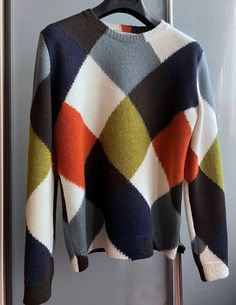 a multicolored sweater hanging on a hanger