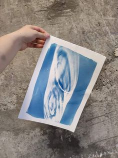 a person holding up a blue and white print