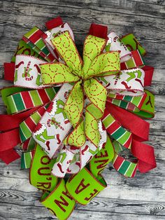 a green and red christmas bow on a wooden surface