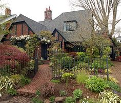 a house with lots of flowers and plants around it