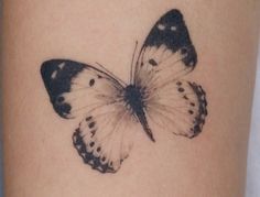 a black and white butterfly tattoo on the leg