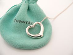 Overview:Everyone needs a signature Tiffany piece! Here is the perfect one just for you - and it is quite a rare and hard to find piece. Offered for sale is a wonderful Tiffany & Co. Peretti Silver Medium Diamond Open Heart Charm necklace. The piece is crafted from bright Tiffany silver, yet retains its feminine and delicate feel. Just gorgeous! Hanging from its bright Tiffany & Co sterling silver curb chain is a gorgeous / classic / and super sparkly Medium Diamond Open Heart Charm. It Open Heart Necklace, Heart Charm Necklace, Gift Love, Open Heart, Charm Gift, Curb Chain, Heart Pendant Necklace, Tiffany & Co., Necklace Pendant