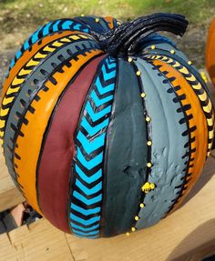 a painted pumpkin sitting on top of a wooden table