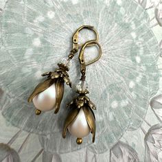 ITEM DETAILS: 🖤 Size and Design: 3 cm long drop earrings featuring a romantic Edwardian Victorian style with elven flower petals 🖤 Materials: Exquisite pearlescent shimmer white pearls with antique brass accents and a matching sparkling little crystal on top 🖤 Functionality: Sturdy leverbacks ensure secure and graceful wear 🖤 Gift: Elegantly packaged for weddings, anniversaries, Christmas, and special presents NOTE - The photo on my hand is for size reference. The colour may differ. ABOUT MY Elegant Brass Flower Earrings Nickel Free, Handmade Elegant Flower Teardrop Earrings, Elegant Handmade Flower Teardrop Earrings, Elegant Handmade Flower Shaped Teardrop Earrings, Elegant Floral Earrings With French Hook, Elegant Flower Shaped Earrings With French Hook, Elegant Teardrop Flower Earrings For Jewelry Making, Elegant Dangle Flower Earrings With French Hook, Vintage Flower Earrings With Ear Wire For Wedding