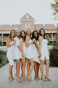 bridesmaids in white dresses posing for the camera