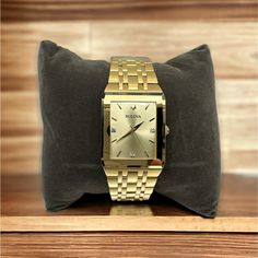 Movement: Three-Hand Quartz Case: Rectangular; 30x45mm Strap: Gold-Tone Stainless Steel Bracelet Dial: Champagne With Diamond-Accent Indices Water Resistance: To 30 Meters Classic Diamond Watch With Date Display As Gift, Rectangular Watches With Date Display, Gold Rectangular Diamond Watch For Business, Anniversary Jewelry And Watches With Metal Rectangular Dial, Rectangular Metal Dial Watch For Anniversary, Rectangular Watches With Date Display For Anniversary, Formal Yellow Gold Stainless Steel Watch Accessories, Classic Gold Rectangular Diamond Watch, Gold Watch With Bracelet Strap And Rectangular Dial