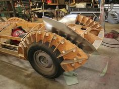 a car made out of wood and metal in a garage