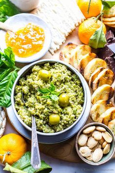 an assortment of food including bread, olives and oranges on a platter