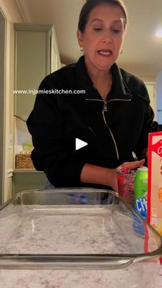 a woman standing in front of a counter filled with milk and other food items on it