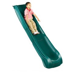 a young boy sitting on top of a green slide