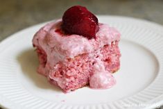 a close up of a piece of cake with frosting and a strawberry on top