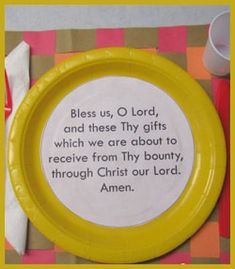 a yellow plate with a poem on it sitting on a checkered table cloth next to a cup