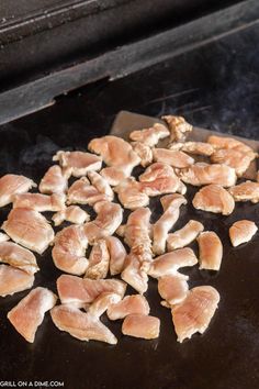 raw chicken is being cooked on the grill