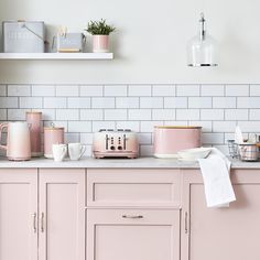 a kitchen with pink cabinets and appliances on the counter top in front of white tiles