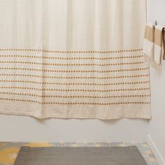 a bathroom with a rug, shower curtain and tiled floor