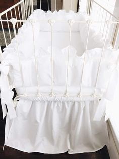 a white crib with ruffles on the bottom