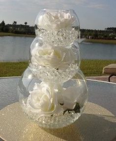 there is a vase with flowers in it on top of a table near the water