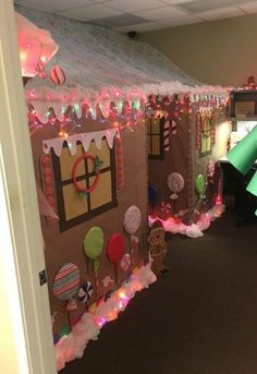 an office decorated for christmas with lights and decorations on the front door, and candy land in the back