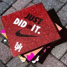 a red graduation cap that says just did it