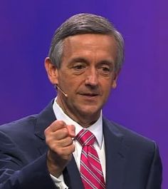 a man in a suit and tie holding his fist up