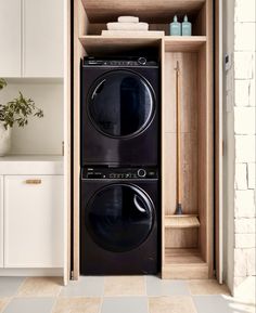 a black washer and dryer sitting in a cabinet next to each other on the floor