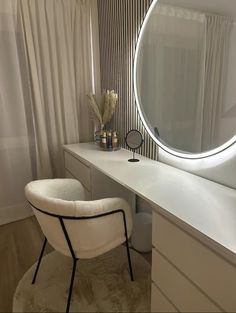 a white chair sitting in front of a vanity with a round mirror on top of it