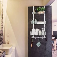 a bathroom with a sink, toilet and shelves on the wall next to each other