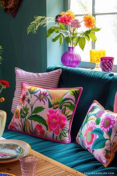 a blue couch with colorful pillows and plates on it