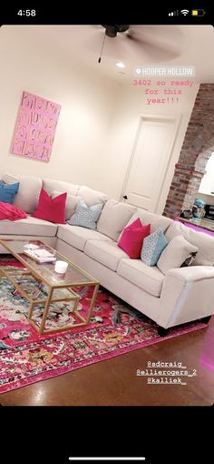 a living room with white couches and colorful pillows on the rug in front of it