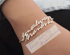 a person wearing a bracelet with writing on it and a name tag attached to the wrist