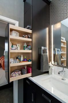 a bathroom with a sink, mirror and shelving unit in the middle of it