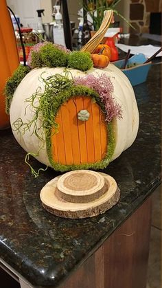 a pumpkin shaped like a hobbot sitting on top of a counter next to a wooden slice