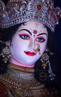 a close up of a statue of a woman wearing jewelry and makeup on her face