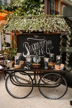 an old fashioned bicycle is decorated with greenery and candles for a wedding or bridal party