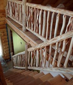 a wooden staircase in a log cabin with wood handrails