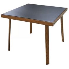 a wooden table with a black top on a white background in front of a white backdrop