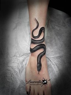 a black and white tattoo on the foot of a person with a snake in it