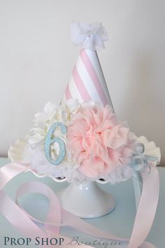 a birthday hat with pink and white flowers on top