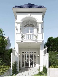 a white house with a blue roof and balconies on the top floor is surrounded by greenery