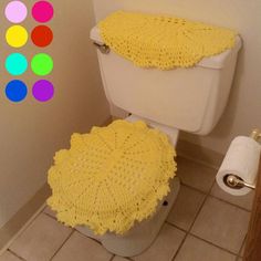 a white toilet covered in yellow crochet next to a roll of toilet paper