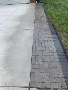 a brick walkway in front of a garage