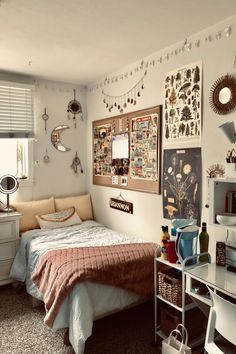 a bed room with a neatly made bed and lots of pictures on the wall above it