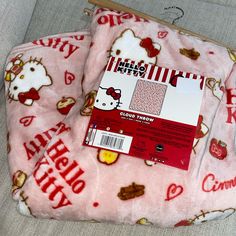 the hello kitty blanket is laying on top of the couch next to it's packaging